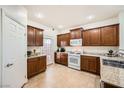 Well-lit kitchen features brown cabinetry, granite countertops, white appliances, and access to the backyard at 6153 Sea Cliff Cove St, North Las Vegas, NV 89031
