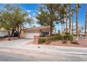Single-story home with a tile roof, two-car garage, and drought tolerant landscaping at 6654 Coronado Crest Ave, Las Vegas, NV 89139