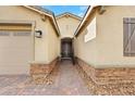 Inviting home entrance with a brick path leading to the front door and a two car garage at 7115 Calvert Cliffs St, North Las Vegas, NV 89084
