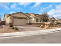Single-story home showcasing desert landscaping, a brick driveway, and a warm-toned exterior at 7115 Calvert Cliffs St, North Las Vegas, NV 89084