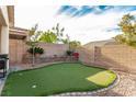 Backyard putting green with desert landscaping, rock accents, privacy walls and mature trees at 7386 Campbell Ranch Ave, Las Vegas, NV 89179