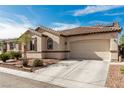 Exterior view of a stucco home with a tiled roof, two-car garage, and solar panels at 7386 Campbell Ranch Ave, Las Vegas, NV 89179