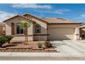 Well-maintained home with a stone-accented garden bed, neutral paint, and a two-car garage at 7386 Campbell Ranch Ave, Las Vegas, NV 89179