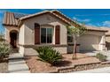 Home with stone accents, brown shutters, desert landscaping, and a two-car garage at 7386 Campbell Ranch Ave, Las Vegas, NV 89179