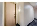 Condo unit entryway with a light wood door and a wall sconce at 75 E Agate Ave # 204, Las Vegas, NV 89123