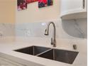 Modern kitchen sink with stainless steel faucet and elegant marble backsplash at 7945 Delbonita Ave, Las Vegas, NV 89147