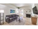 Bright living room with gray sofa, fireplace, and sliding glass doors to balcony at 8408 Running Deer Ave # 201, Las Vegas, NV 89145