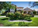 Charming home exterior with beautiful landscaping, colorful flowers, and a stone-paved driveway at 9533 Orient Express Ct, Las Vegas, NV 89145