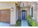 Close-up of front door with stone accent, muted blue color, and lush green ground cover at 9992 Sky Parlor Rd, Las Vegas, NV 89178