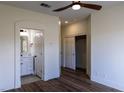Bright main bedroom with wood-look floors, a ceiling fan, and access to an ensuite bathroom at 1100 Warm Canyon Way, Las Vegas, NV 89123