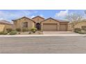 Inviting single-story home with a well-manicured front yard and a paver driveway leading to a three-car garage at 11274 Felice Cohn Ct, Las Vegas, NV 89179