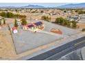 Expansive aerial view showcases the home and surrounding community with mature trees and a large gravel lot at 1800 Red Rock Dr, Pahrump, NV 89048