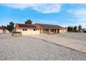 View of house and driveway with solar panels, red tile roof and mature trees in a big lot at 1800 Red Rock Dr, Pahrump, NV 89048