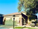 Charming home featuring a two-car garage, stone accents, and well-maintained landscaping, creating curb appeal at 3538 Old Course St, Las Vegas, NV 89122