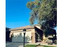 This home features a two-car garage with a concrete driveway and desert landscaping at 3538 Old Course St, Las Vegas, NV 89122