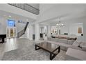 Bright, open-concept living room with staircase, tile flooring, and contemporary furnishings at 3921 Jacob Lake Cir, Las Vegas, NV 89118