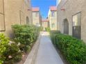 Well-maintained walkway between condo buildings with lush green hedges and desert landscaping at 4704 Obannon Dr # D, Las Vegas, NV 89102