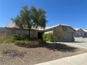 Charming single-story home with well-maintained desert landscaping and mature trees in front yard at 511 Credence Ave, Henderson, NV 89002