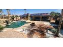 This backyard boasts a large pool with waterfall, fire pit, and lounge area with solar panels on the home at 5312 Manuel Dr, Las Vegas, NV 89149