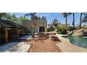 Beautiful backyard with pool, waterfall feature, outdoor kitchen, and brick patio perfect for entertaining at 5312 Manuel Dr, Las Vegas, NV 89149