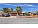 Charming single-story home features a two-car garage and desert landscaping with a secure chain link fence at 625 Fernbrook Dr, Henderson, NV 89002