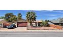 Charming single-story home features a two-car garage and desert landscaping with a secure chain link fence at 625 Fernbrook Dr, Henderson, NV 89002