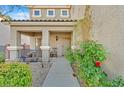 Cozy front porch and entryway with desert landscaping and decorative greenery at 65 Pangloss St, Henderson, NV 89002