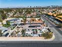 The residence boasts solar panels and ample space, as seen from this aerial view, near the cityscape at 6882 Palmyra Ave, Las Vegas, NV 89146