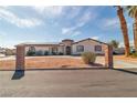 This charming single-story house is accented by a turret entry, desert landscaping, and a circular driveway at 6882 Palmyra Ave, Las Vegas, NV 89146