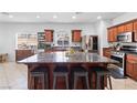 Spacious kitchen boasts dark wood cabinetry, stainless steel appliances, and a large center island with seating at 7641 Lani Dawn St, Las Vegas, NV 89149