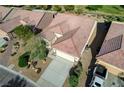 Birds-eye view of a charming home with a well-maintained roof, desert landscape, and attached two-car garage at 7760 Pine Warbler Way, North Las Vegas, NV 89084