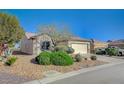 Inviting curb appeal of a single-story home with low-maintenance desert landscaping and a paved driveway at 7760 Pine Warbler Way, North Las Vegas, NV 89084