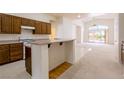 Open kitchen with wooden cabinets, a breakfast bar, and views into the living area at 8249 Jo Marcy Dr, Las Vegas, NV 89131