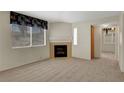 Cozy living room features a fireplace, a large window, and soft, neutral carpet at 8725 W Flamingo Rd # 240, Las Vegas, NV 89147