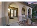 Elegant front porch featuring stone accents, graceful archways, and decorative front doors at 9008 Sawhill Pond St, Las Vegas, NV 89131