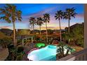 Backyard oasis with a sparkling pool, rock waterfall feature, spa, and covered patio at 9008 Sawhill Pond St, Las Vegas, NV 89131