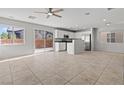 Bright, open-concept living area with neutral tile floors, a ceiling fan, and sliding glass doors at 9543 Havasu Canyon Ave, Las Vegas, NV 89166