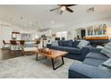 An open concept living room with modern furniture, flowing into a breakfast bar and kitchen at 11244 Playa Caribe Ave, Las Vegas, NV 89138