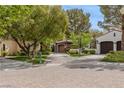 Charming home with a brick driveway, well-manicured lawn, and mature trees at 11814 Canons Brook Dr, Las Vegas, NV 89141