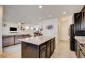 Open kitchen layout with island featuring granite countertops and seamless flow to the living area at 12391 Pinetina St, Las Vegas, NV 89141