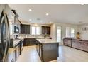 Spacious kitchen with stainless steel appliances, granite countertops, and island overlooks the living area at 12391 Pinetina St, Las Vegas, NV 89141