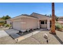 Desert-style home with a two-car garage, drought-tolerant landscaping, and walkway lighting at 2099 Desert Woods Dr, Henderson, NV 89012