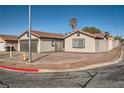 Single-story home featuring a two-car garage, desert landscaping, and block perimeter fence at 239 Eugene Way, Henderson, NV 89015