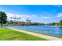 Beautiful waterfront view of the lake with sidewalks and green grass, perfect for walking and enjoying outdoors at 3125 N Buffalo Dr # 1133, Las Vegas, NV 89128