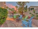 Inviting backyard features a stone patio with Adirondack chairs around a fire pit, perfect for gatherings at 4651 Munich Ct, Las Vegas, NV 89147