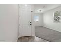 Inviting entryway with a white front door leading into a brightly lit, carpeted living space at 5317 Golden Melody Ln, North Las Vegas, NV 89081