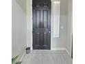 Elegant dark-colored front door with tile flooring and bright sidelight at 7114 Superstar St, North Las Vegas, NV 89084