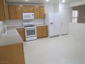 Well lit kitchen with a white refrigerator and tan cabinets at 7173 Las Colinas Ave, Las Vegas, NV 89179