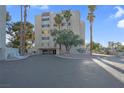 Inviting condo building featuring well-manicured landscaping and mature palm trees under a bright blue sky at 725 N Royal Crest Cir # 246, Las Vegas, NV 89169