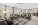 Open-concept living room featuring tile floors and modern furniture at 7714 Duran Harbor Ln, North Las Vegas, NV 89084